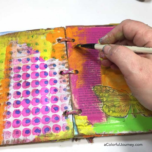 Video tutorial adding layers of color in a cardboard art journal with Carolyn Dube