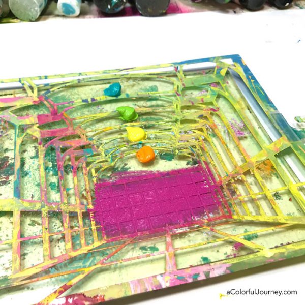 Gel printing with a stencil into an art journal to create a rainbow room tutorial by Carolyn Dube