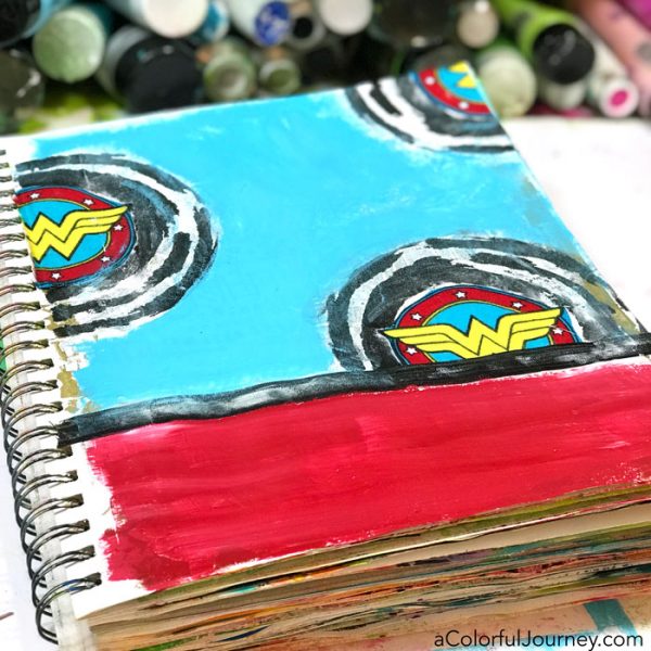 Playing in an art journal with Wonder Woman scraps and stencils and baby wipes by Carolyn Dube