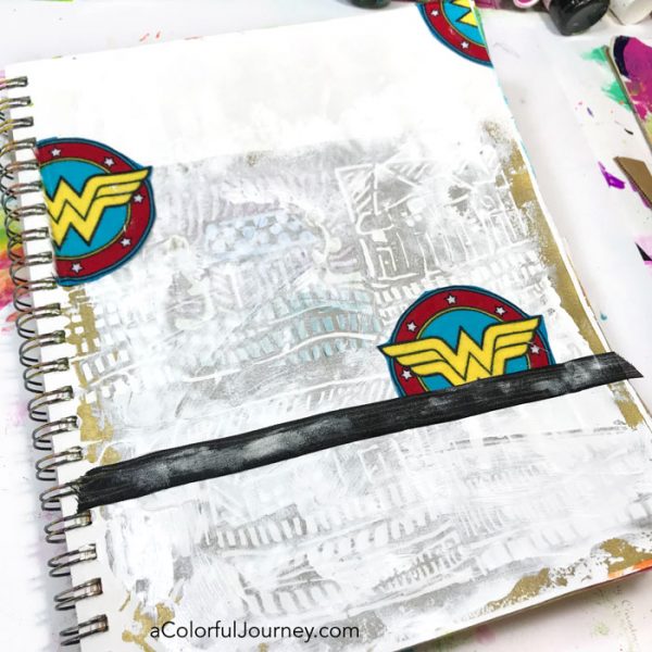 Playing in an art journal with Wonder Woman scraps and stencils and baby wipes by Carolyn Dube