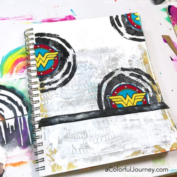 Playing in an art journal with Wonder Woman scraps and stencils and baby wipes by Carolyn Dube