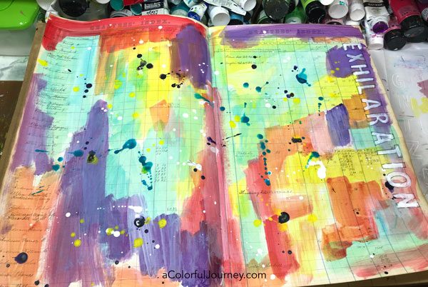 Splattering Pam Carriker paints and a quick stenciled title in a vintage art journal video by Carolyn Dube